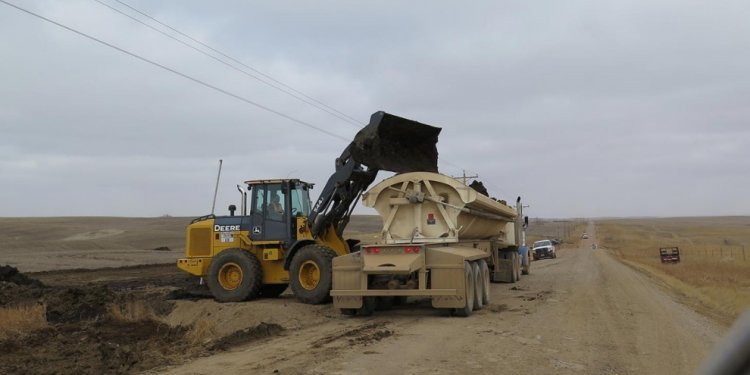 Clean-up workers load dirt