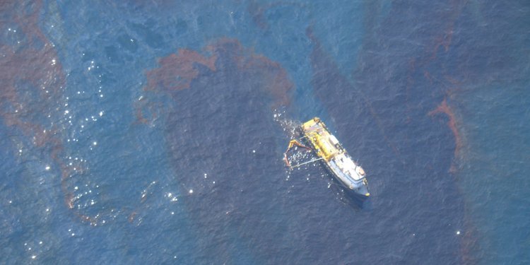 A vessel skims surface oil