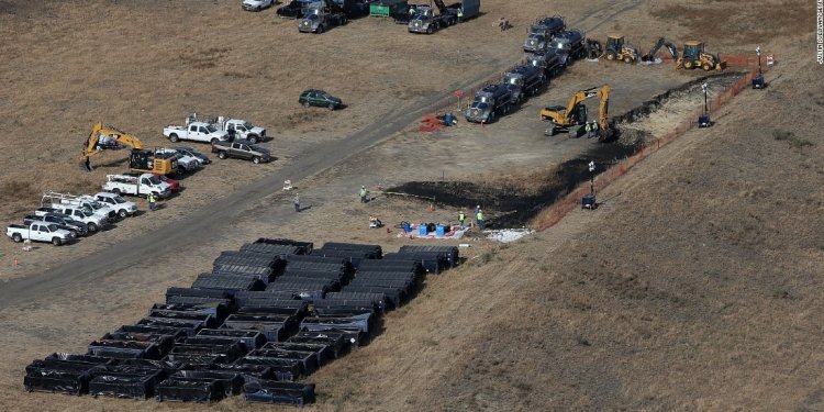 Workers clean up the site near