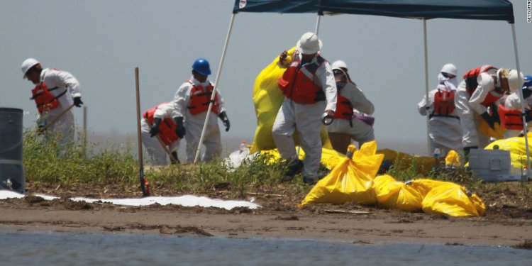 Workers clean a beach in South