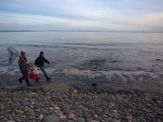 PHOTO: Local residents Josh Marsh,  left,  and Morgan Miller,  correct,  patrol the oil-covered beach for distressed wildlife  may 19,  2015 north of Goleta,  Calif.