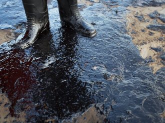 PHOTO: Oil surrounds your toes of local resident Morgan Miller while he patrols the beach for oiled wildlife on 19, 2015 north of Goleta, Calif.